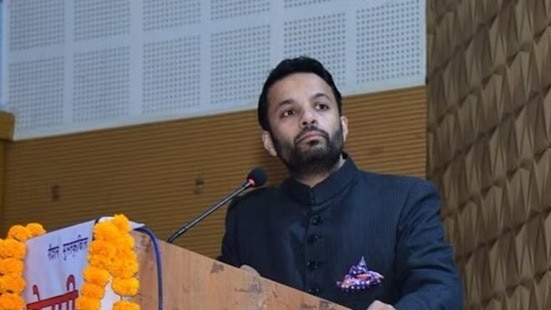 A man wearing navy blue coat on podium