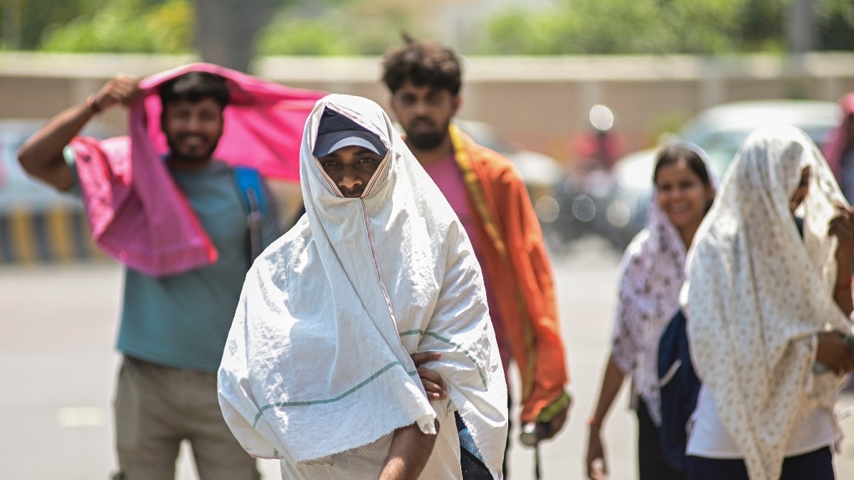 Pedestrians cover their heads for protection from the heat 