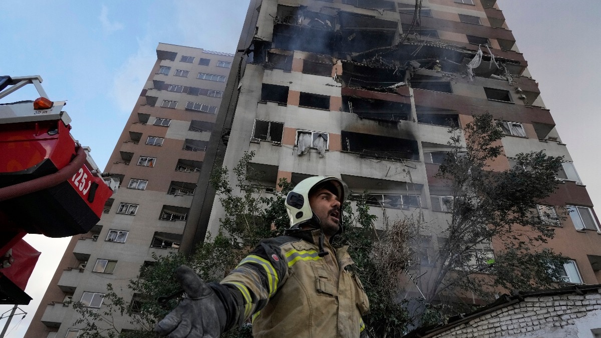 13 को ईरान के उत्तरी तेहरान में एक आवासीय परिसर में हुए विस्फोट के बाद रेस्क्यू में जुुटा अग्निशमन कर्मी (फोटो - AP)