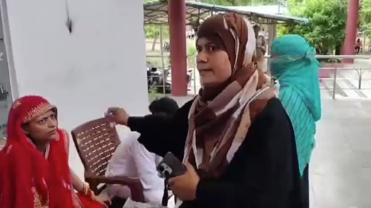 लाल साड़ी में बैठी लड़की, सामने खड़े परिजन