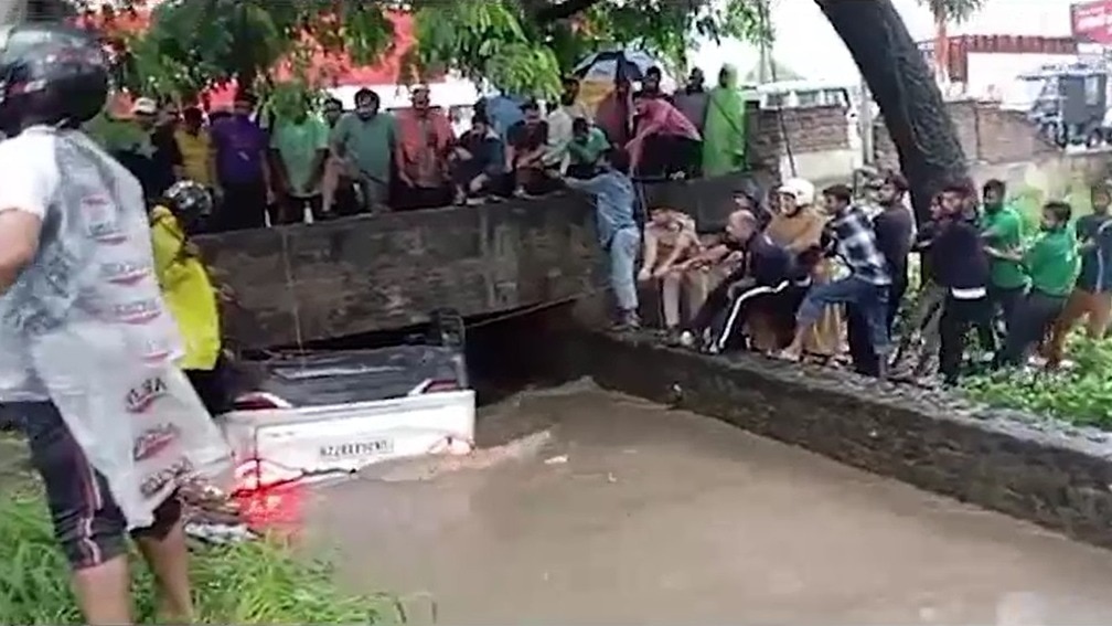 कार को स्थानीय लोगों की मदद से बाहर निकालती रेस्क्यू टीम