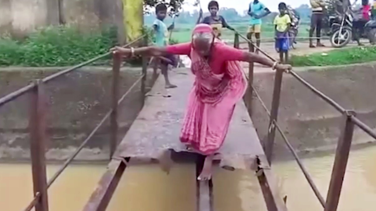 जंग लगे ढांचे पर चलने को मजबूर लोग.