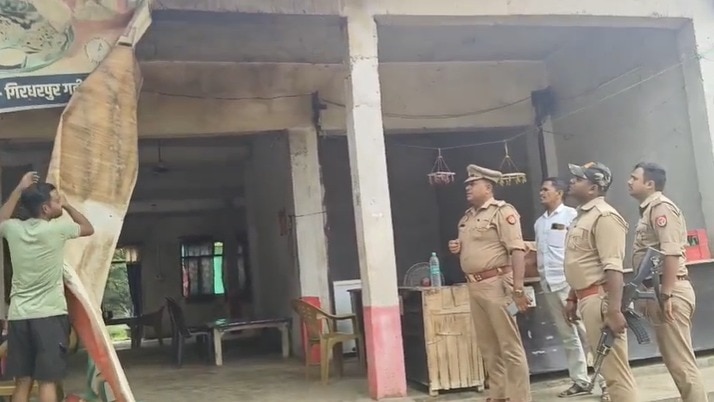 फर्जी पहचान से संचालित होटल का साइनबोर्ड हटवाते हुए पुलिसकर्मी.