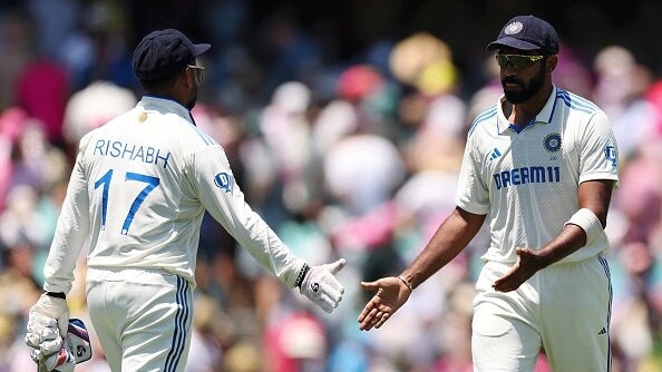 Jasprit Bumrah of India interacts with teammate Rishabh Pant while leaving the field for lunch