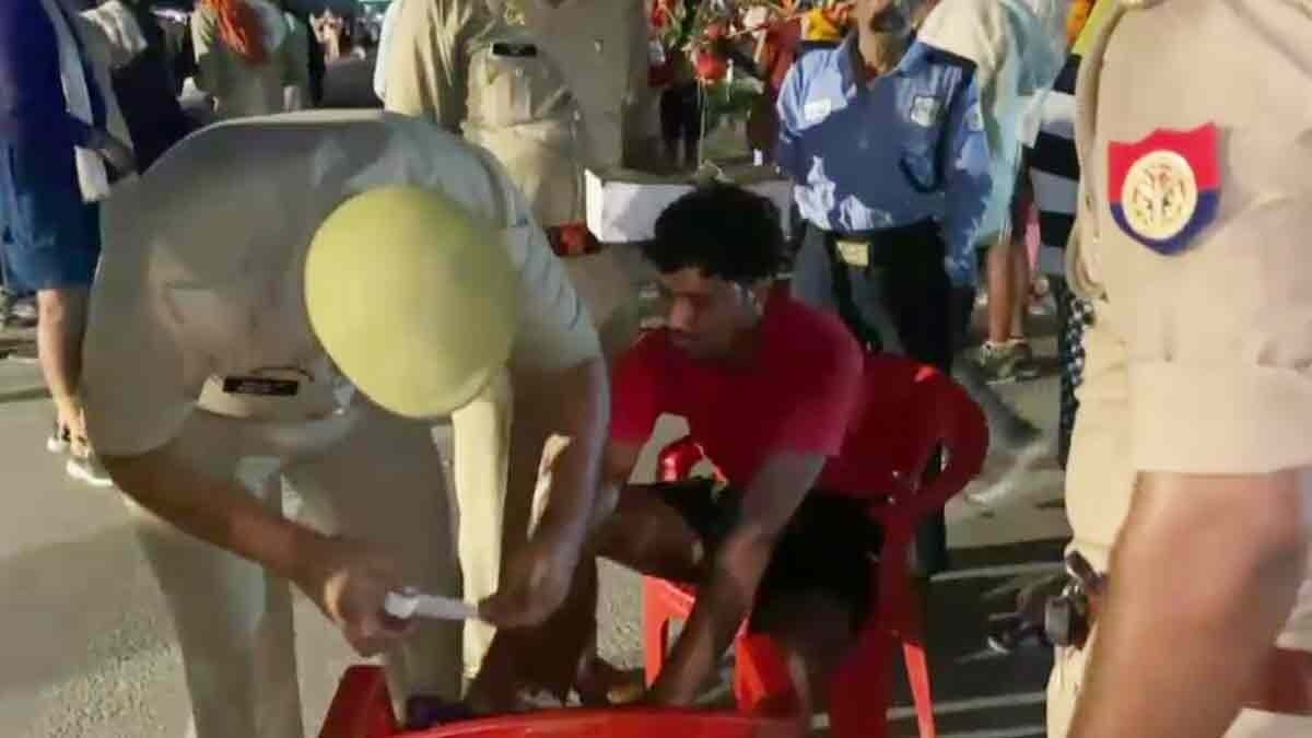 कांवड़ियों के जख्मों पर मरहम लगाते पुलिसकर्मी (Photo: Screengrab)
