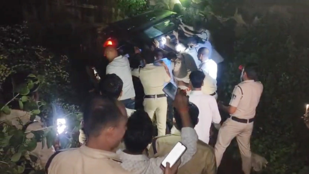 कार के नीचे दबे कावड़ियों को निकालते पुलिसकर्मी.