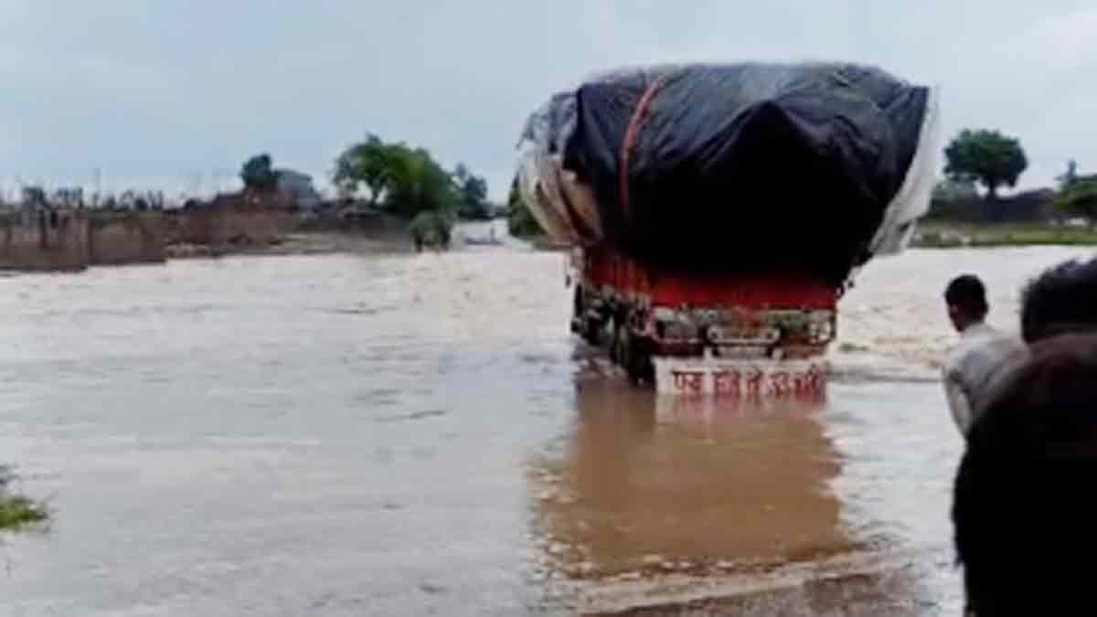 नदी में उफान के बावजूद ट्रक निकालता ड्राइवर (Photo: Himanshu Purohit/ITG)