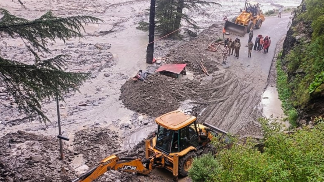 An excavator being used to clear debris from a road following flash floods triggered by a cloudburst, near Harsil in Uttarkashi (PTI Photo)