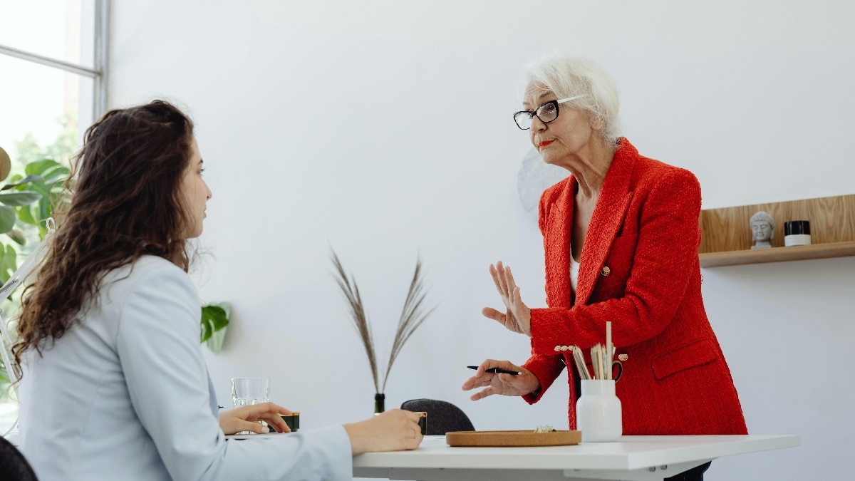 two women talking to each other in office 