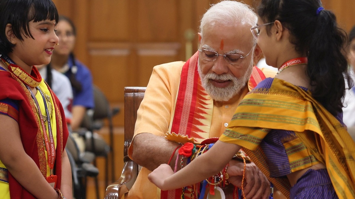 Girl tying Rakhi to PM Modi