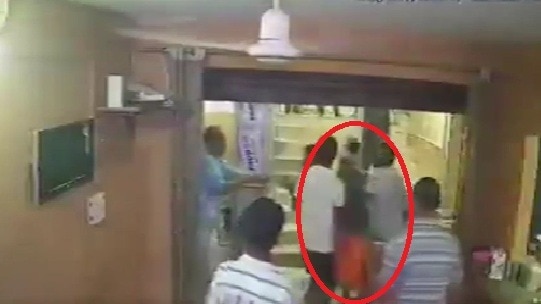 भगवा वस्त्र पहनकर चिकन खाने वाले की पिटाई करते लोग. (Photo: Screengrab)