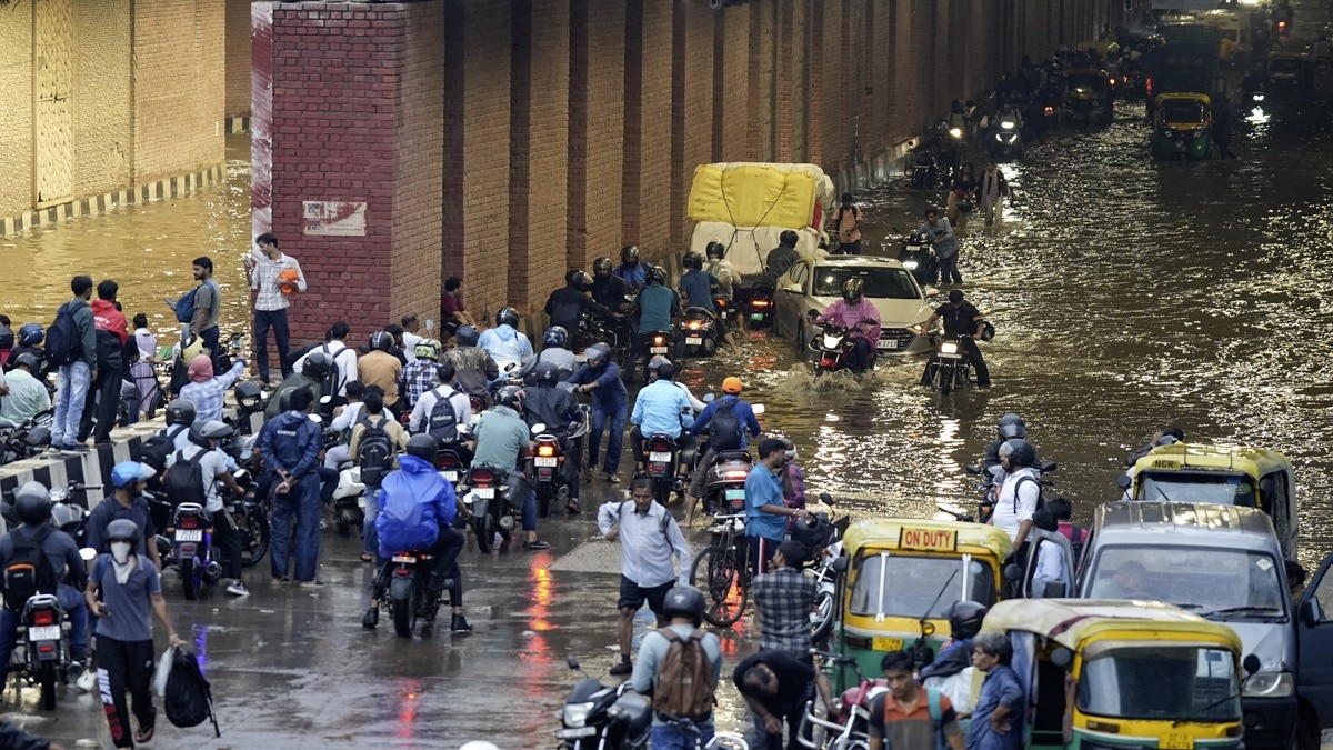 Vehicles move through the waterlogged Sarita Vihar underpass during a rainy morning, in New Delhi