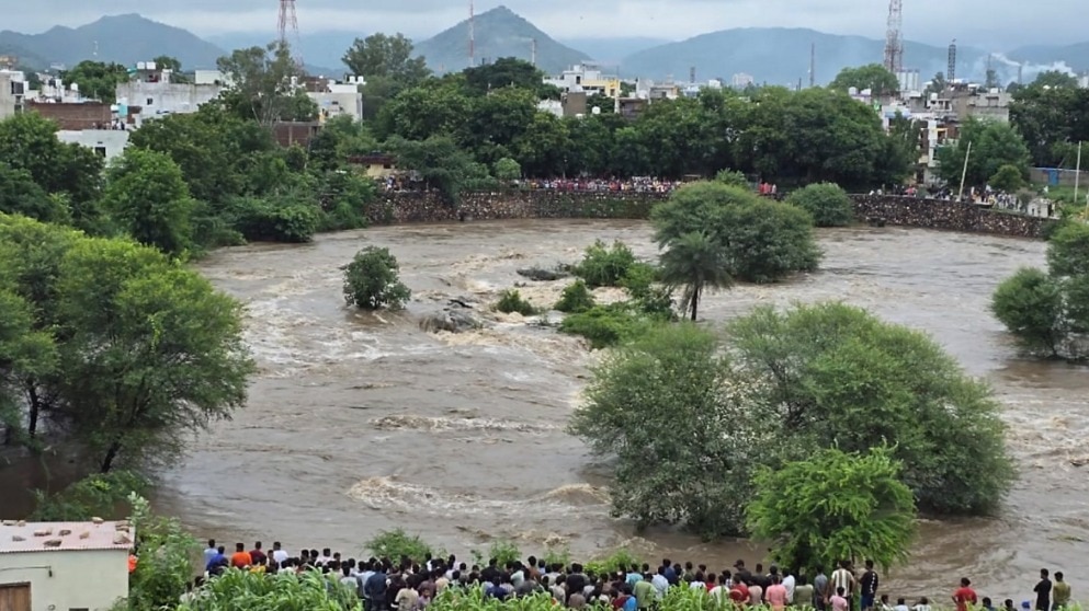 People look on as army personnel rescue a man trapped in a river, in Udaipur, Rajasthan, Sunday, Sept. 7, 2025. (PTI Photo