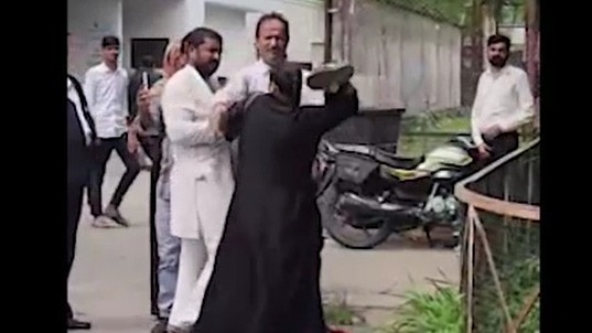 कोर्ट के बाहर पति और ससुर की पिटाई करती महिला. (Photo: Screengrab)