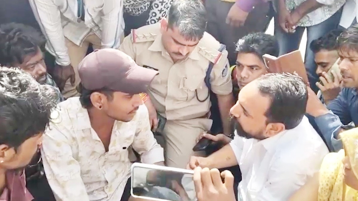 धरने पर बैठे मृतक के परिजनों को समझाती पुलिस.(Photo:Screengrab)
