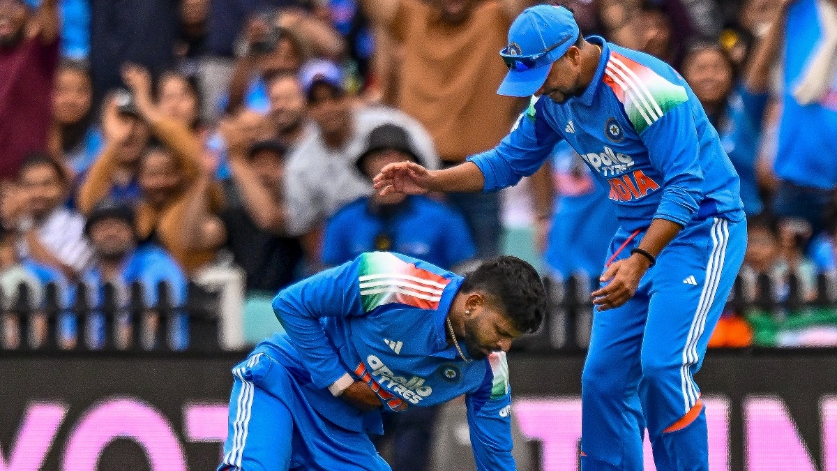 Shreyas Iyer reacts after sustaining an injury while taking the catch of Australia's Alex Carey