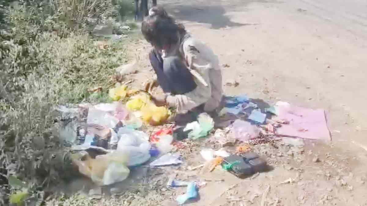 video of child searching for food in the garbage