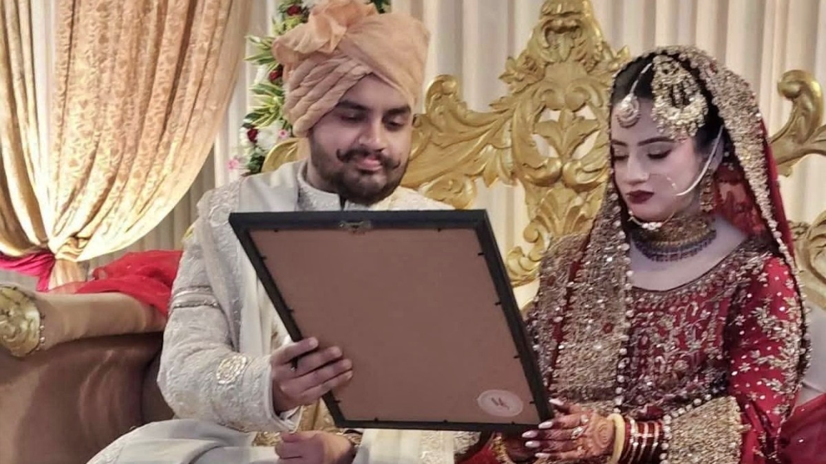 Umar Ansari showing his wife a photo of his father Mukhtar (Photo- ITG)