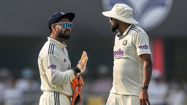 India's captain Rishabh Pant (L) speaks with his teammate Mohammed Siraj