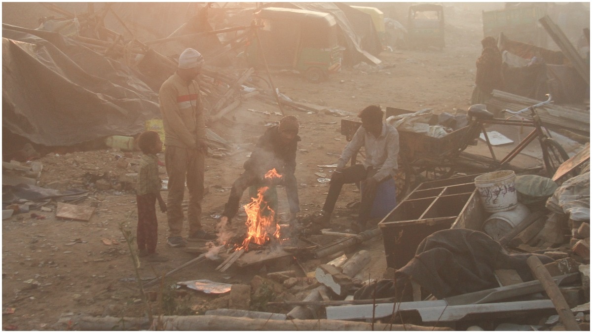 People sit around a bonfire on a cold winter morning, in Gurugram