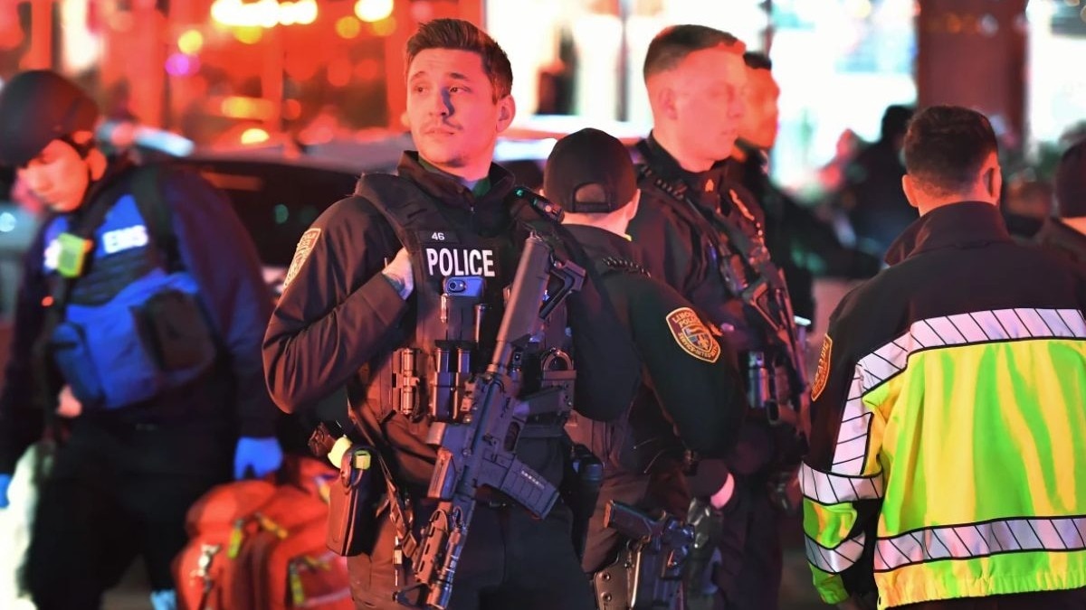 Law enforcement officials carrying weapons gather near Brown University in Providence on Saturday, during the investigation of a shooting. (AP Photo)