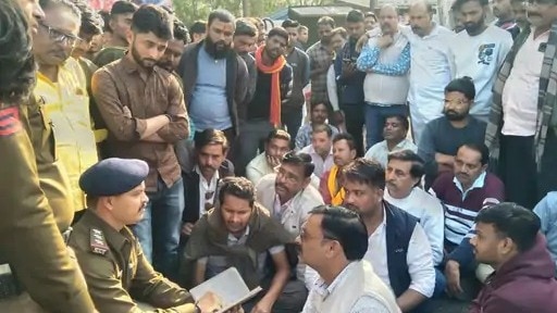 लूट के बाद गुस्साएं व्यापारियों को समझाते पुलिस अधिकारी (Photo:ITG)