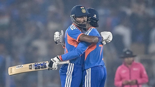 India's Hardik Pandya (L) celebrates with teammate Tilak Varma after scoring a half-century (50 runs) during the fifth Twenty20 international cricket match between India and South Africa at the Narendra Modi Stadium in Ahmedabad on December 19, 2025