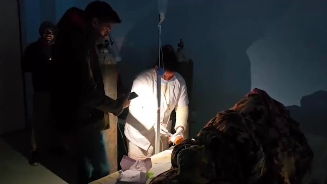 अस्पताल में लाइट कटने के बाद मोबाइल की टॉर्च से ट्रीटमेंट करते डॉक्टर. (Photo: Screengrab)