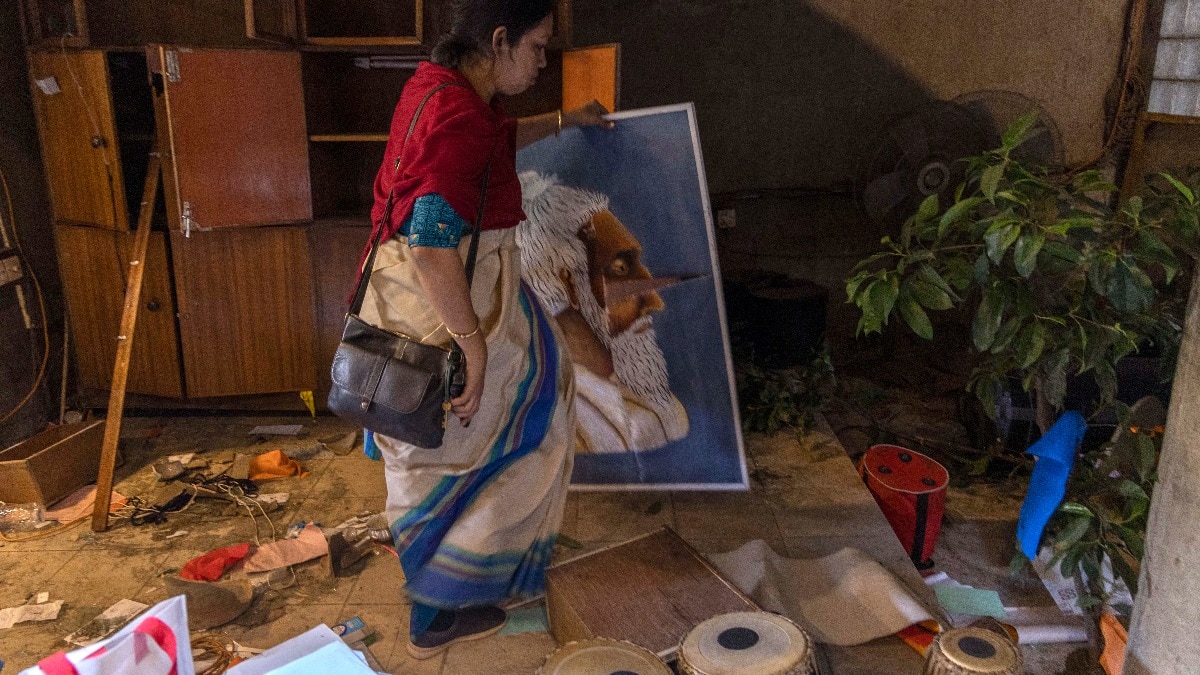 An employee arranges the vandalised office of the Chhayanaut
