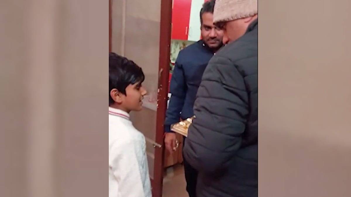 पुलिस को चॉकलेट का पैकेट दिखाता बच्चा.(Photo:Screengrab)