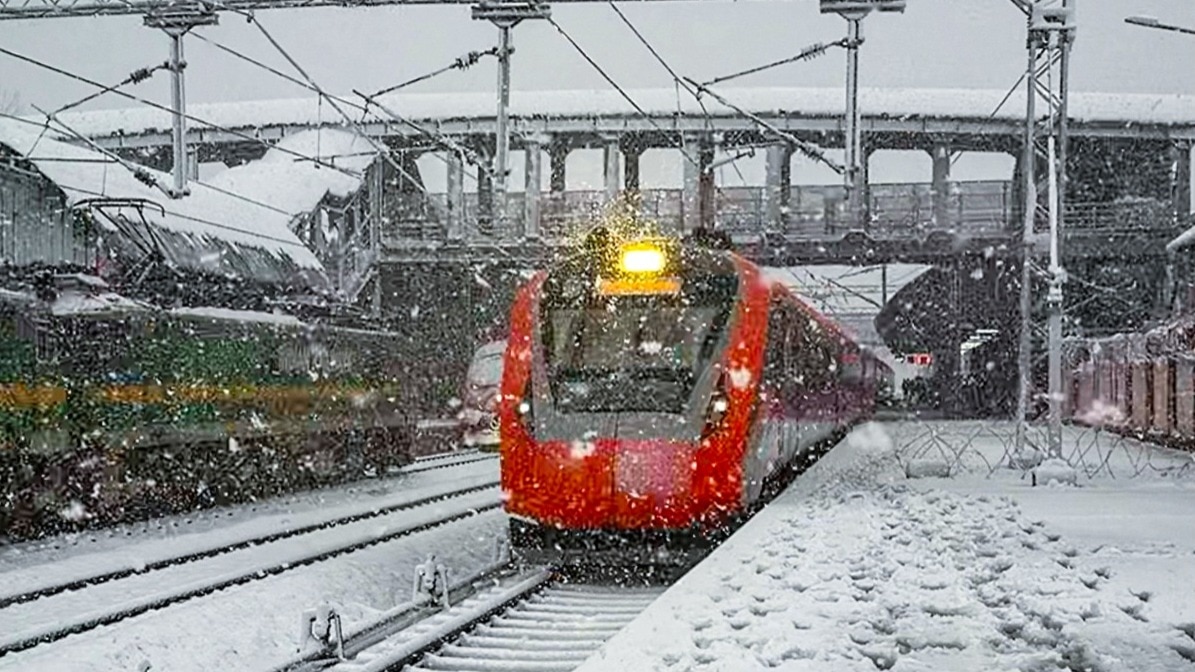 श्रीनगर में कटरा-श्रीनगर रेल सेक्शन पर बर्फबारी के बीच गुजरती ट्रेन (Photo: PTI)