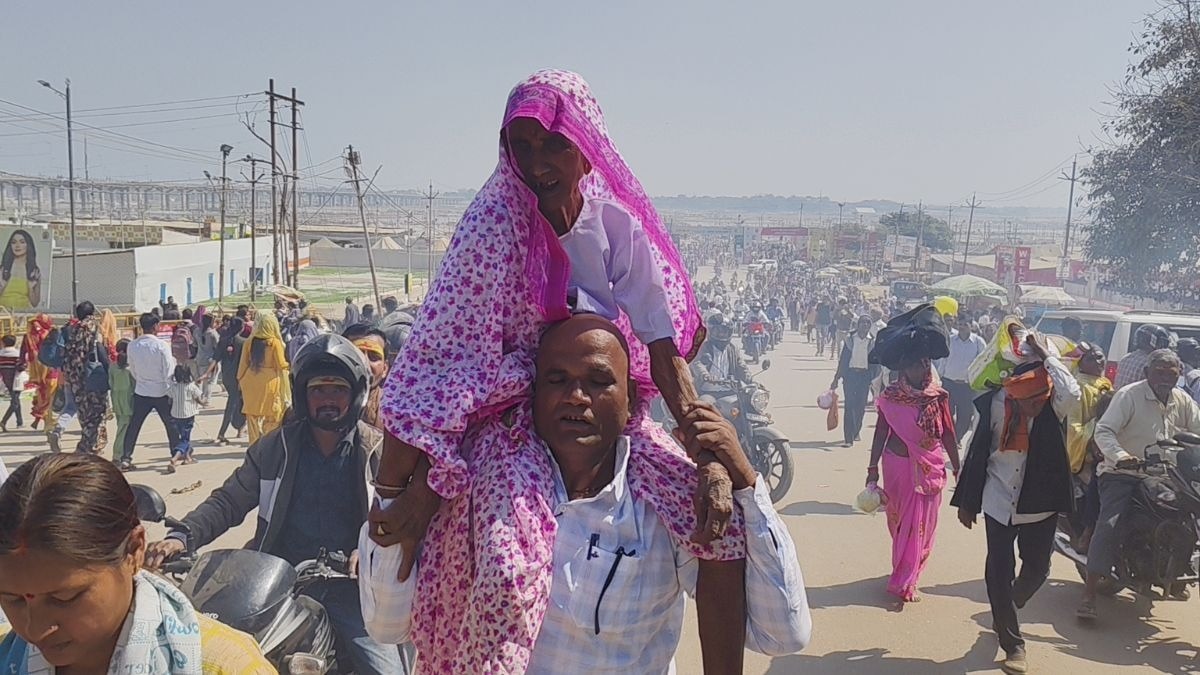 कंधे पर उठाकर मां को संगम स्नान कराने पहुंचा बेटा. (Photo: ITG)