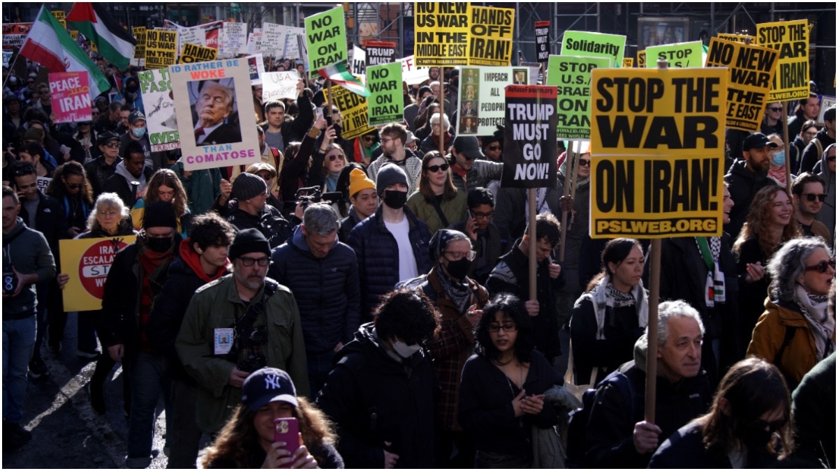 People hold placards during the Stop the War on Iran protest at Times Square in New York City 