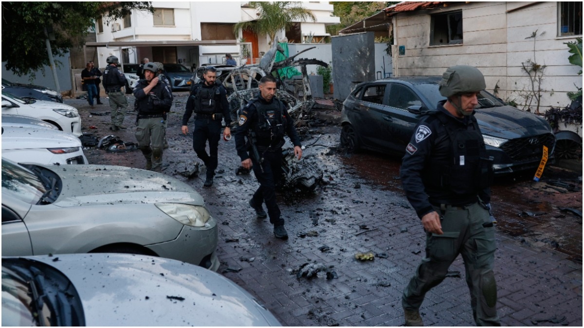 Israeli policemen survey a missile attack from Iran in Rosh HaAyin, Israel