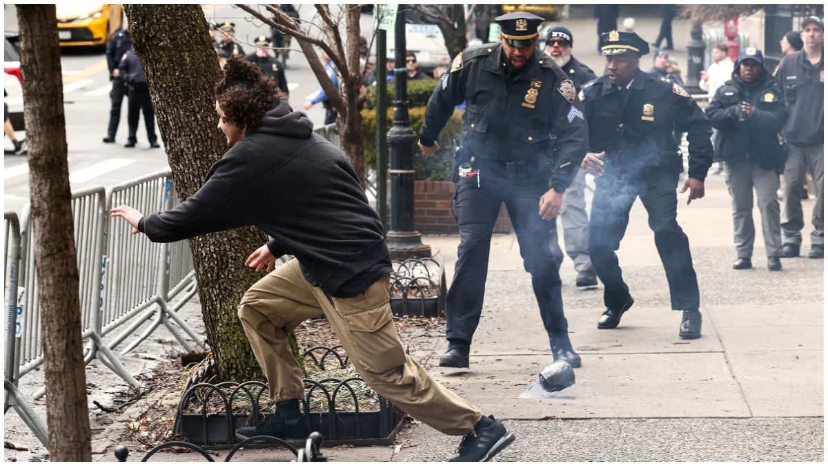 A young man throws a smoke device and runs away during an anti-Islam protest outside the home of New York Mayor Zohran Mamdani