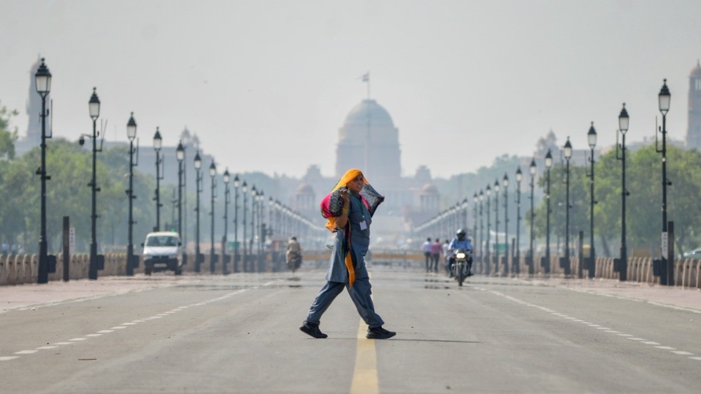 New Delhi A woman covers her head with a cloth while crossing Kartavya Path on a hot afternoon, in New Delhi (PTI Photo)