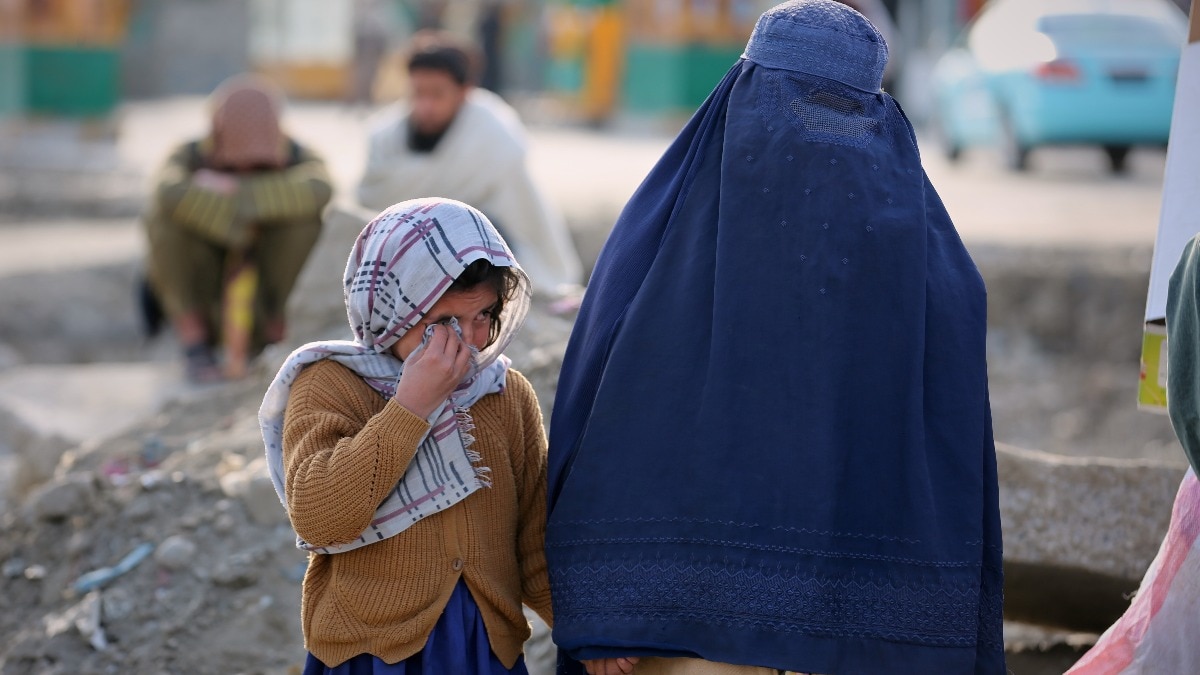 काबुल में अस्पताल के पास परिजनों को खोजती एक बच्ची और एक महिला. (Photo: AP)
