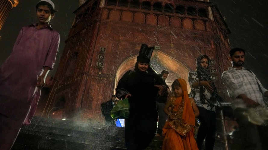 धूल भरी आंधी, तेज हवाओं, गरज-चमक और बारिश के बीच लोग (Photo-PTI)