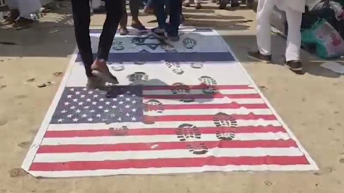 कर्नाटक के गांव में अमेरिकी झंडों पर जूते चप्पलों से चलकर प्रदर्श किया गया (Photo: Screengrab)
