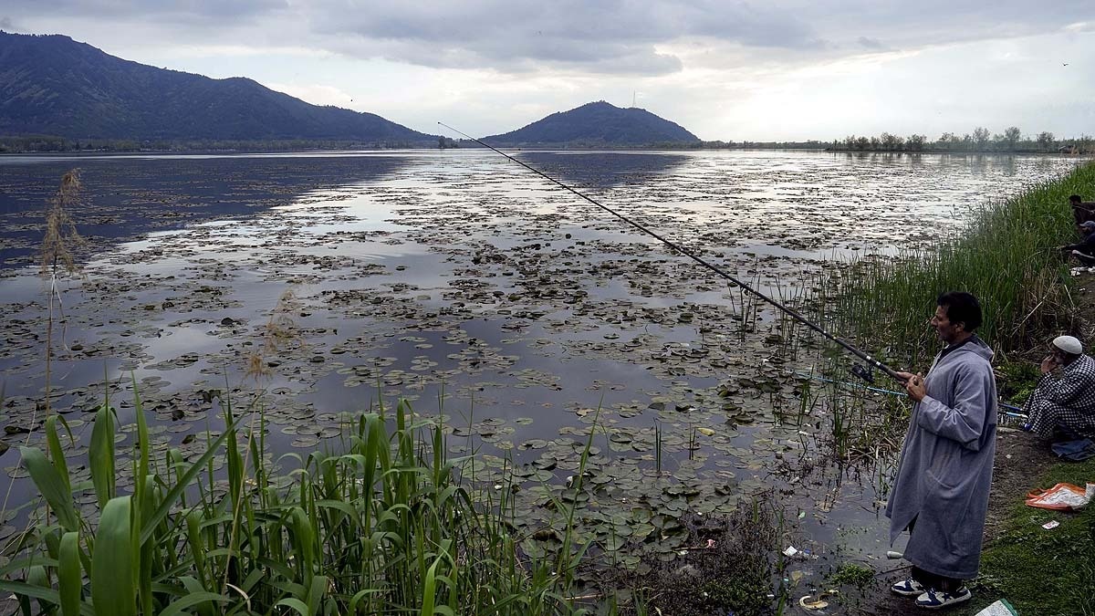 श्रीनगर में डल झील पर मछली पकड़ता एक शख्स. (Photo: PTI)