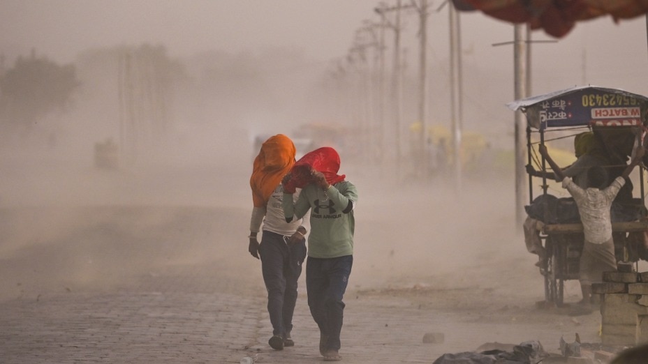 Commuters make their way through a dust storm, in Prayagraj, Uttar Pradesh, May 13, 2026. (PTI Photo) 