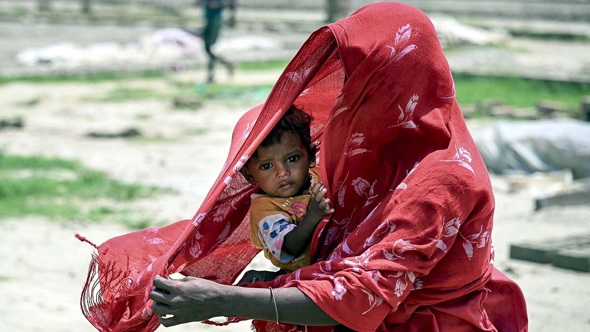 पश्चिम बंगाल के नादिया में भयानक गर्मी से बच्चे को बचाती मां. (Photo: PTI)