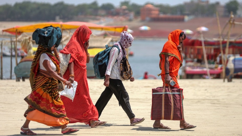 People walk with their faces covered to protect themselves from the heatwave on a hot summer day (PTI Photo)