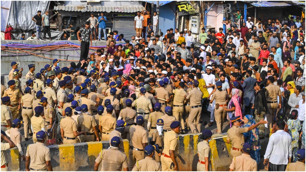 मुंबई के बांद्रा रेलवे स्टेशन के पास गरीब नगर झुग्गी बस्ती में अतिक्रमण विरोधी अभियान के दौरान हुई झड़पों में पुलिसकर्मियों ने लाठीचार्ज किया. (Photo: PTI)