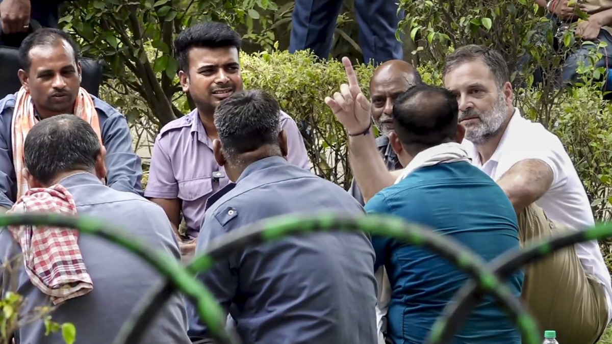 दिल्ली में ऑटो ड्राइवरों के साथ जमीन पर बैठकर बातचीत करते राहुल गांधी (Photo: PTI)