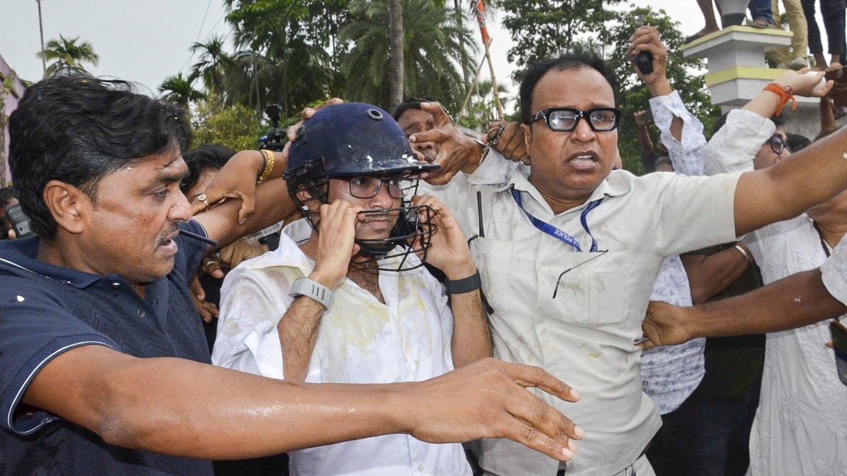 TMC General Secretary Abhishek Banerjee wears a helmet after stones, shoes and eggs were hurled at him during his visit to meet families of post-poll violence victims in Sonarpur. (PTI Photo)