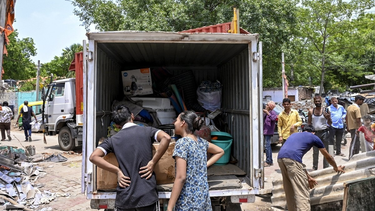 लुटियंस दिल्ली में झुग्गी बस्तियों से अपना सामान ले जाते लोग.(Photo:PTI)