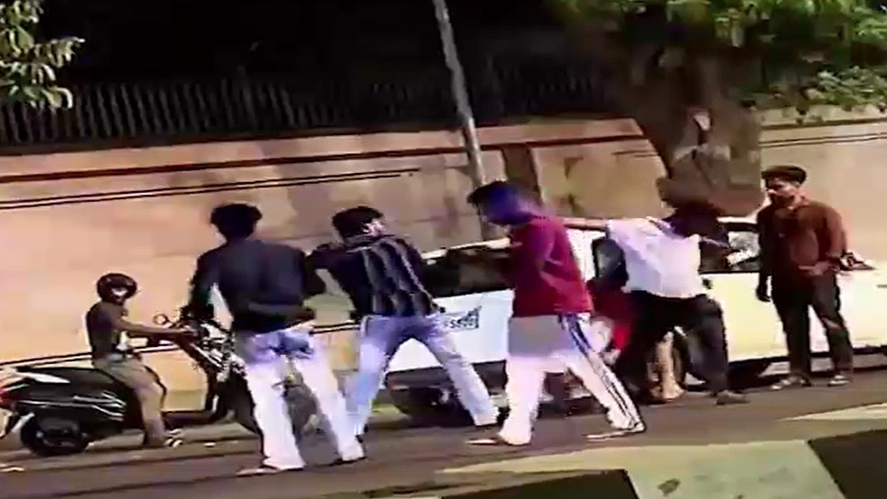 बीच सड़क युवक की पिटाई करते दबंग. (Photo: Screengrabs)