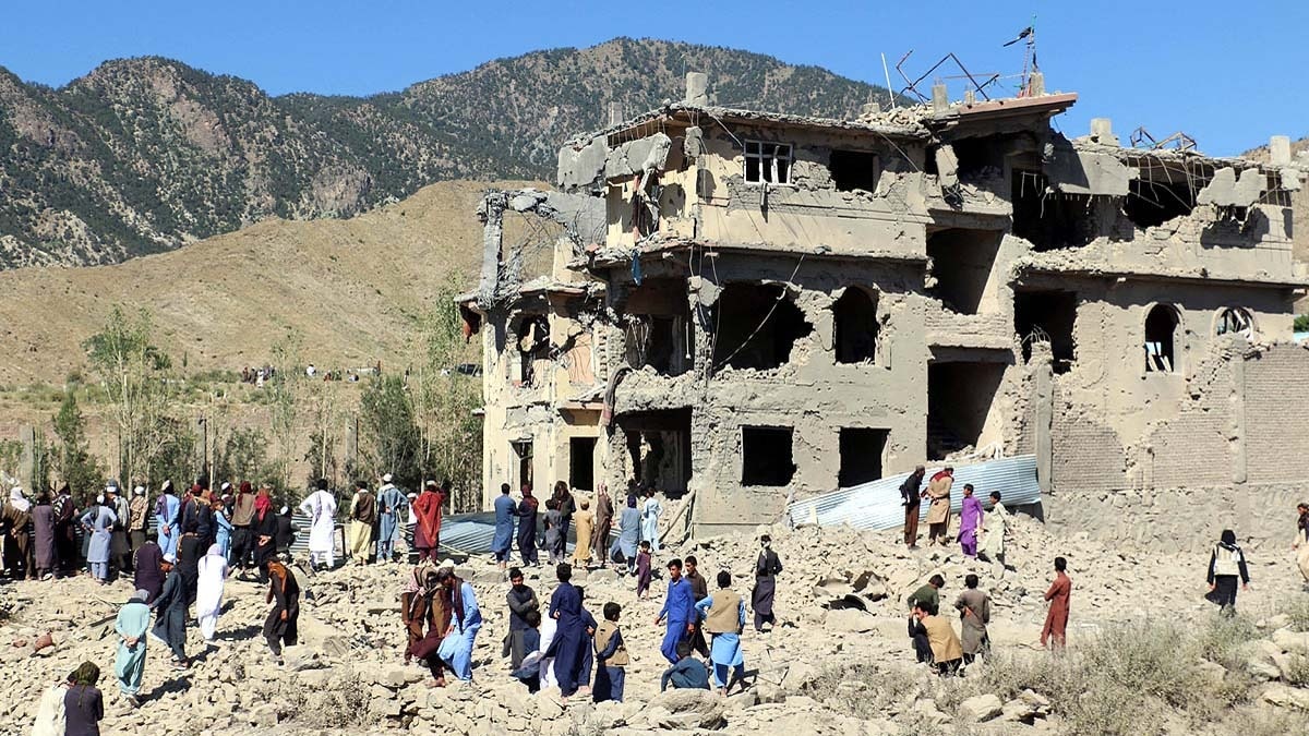 अफगानिस्तान के पक्तिका प्रांत के समकनी जिले में पाकिस्तानी एयरस्ट्राइक के बाद बर्बाद इमारत के पास मौजूद स्थानी निवासी और तालिबान के लोग. (Photo: Reuters)
