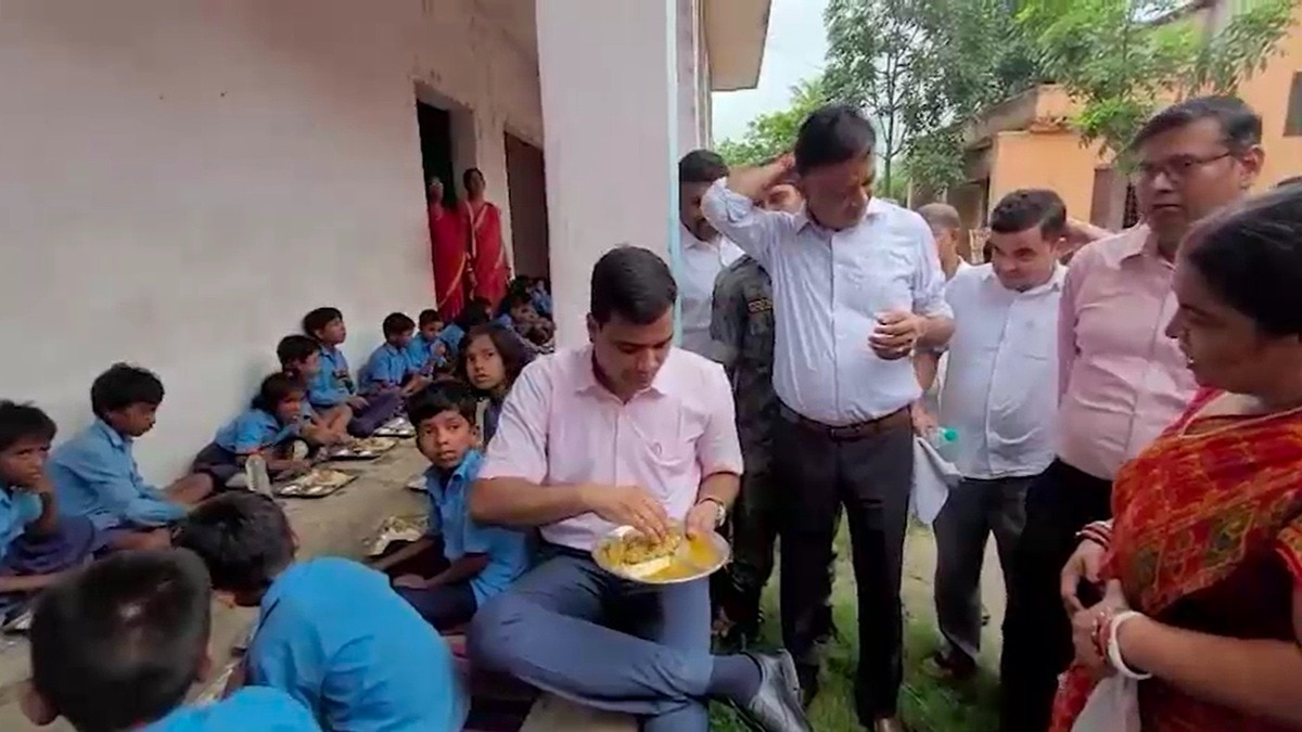 बच्चो के बीच बैठ मिड डे मील का खाना खाते कटिहार डीएम. (Photo: Screengrabs) 